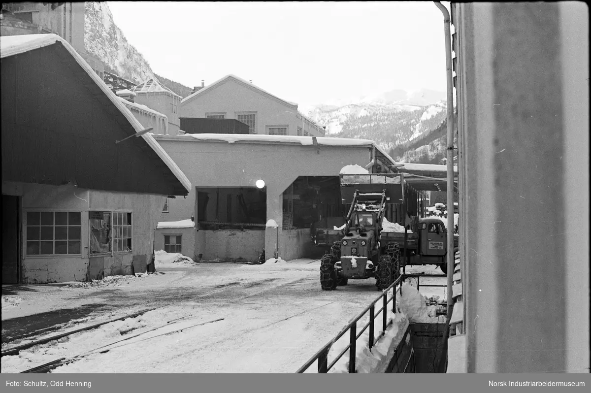Hjullaster som rydder snø på fabrikkområde.