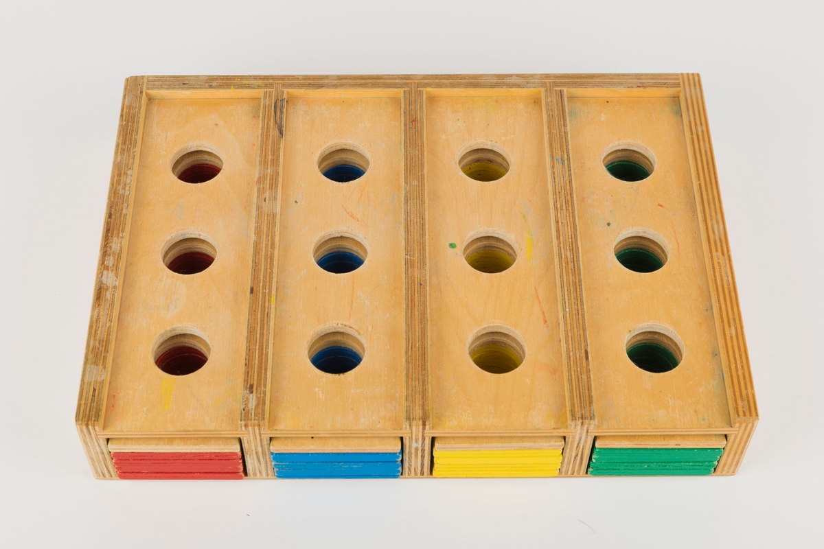 Spillboks med 12 figurbrikker og 20 flate, rektangulære brikker. Figurbrikkene stikkes i hull i spillboksen og går gjennom hull i de flate brikkene. Hullene har en diameter på 2,7 cm.

3 røde, 3 blå, 3 gule og 3 grønne figurbrikker. Brikkene måler 11 x 2,5 cm. 

4 røde, 4 blå, 4 gule, 4 grønne og 4 trefargede flate brikker. Brikkene måler 19,5 x 5,6 cm og er 0,6 cm tykke.
