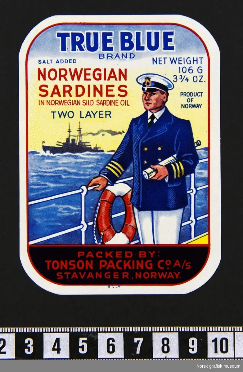 Etikett med en illustrasjon av en uniformskledd mann som står ved en (trolig) skipsreling og en livbøye. Under armen har han en kikkert, og i bakgrunnen ser vi et annet skip i horisonten. 

"Norwegian sardines in Norwegian sild sardine oil"