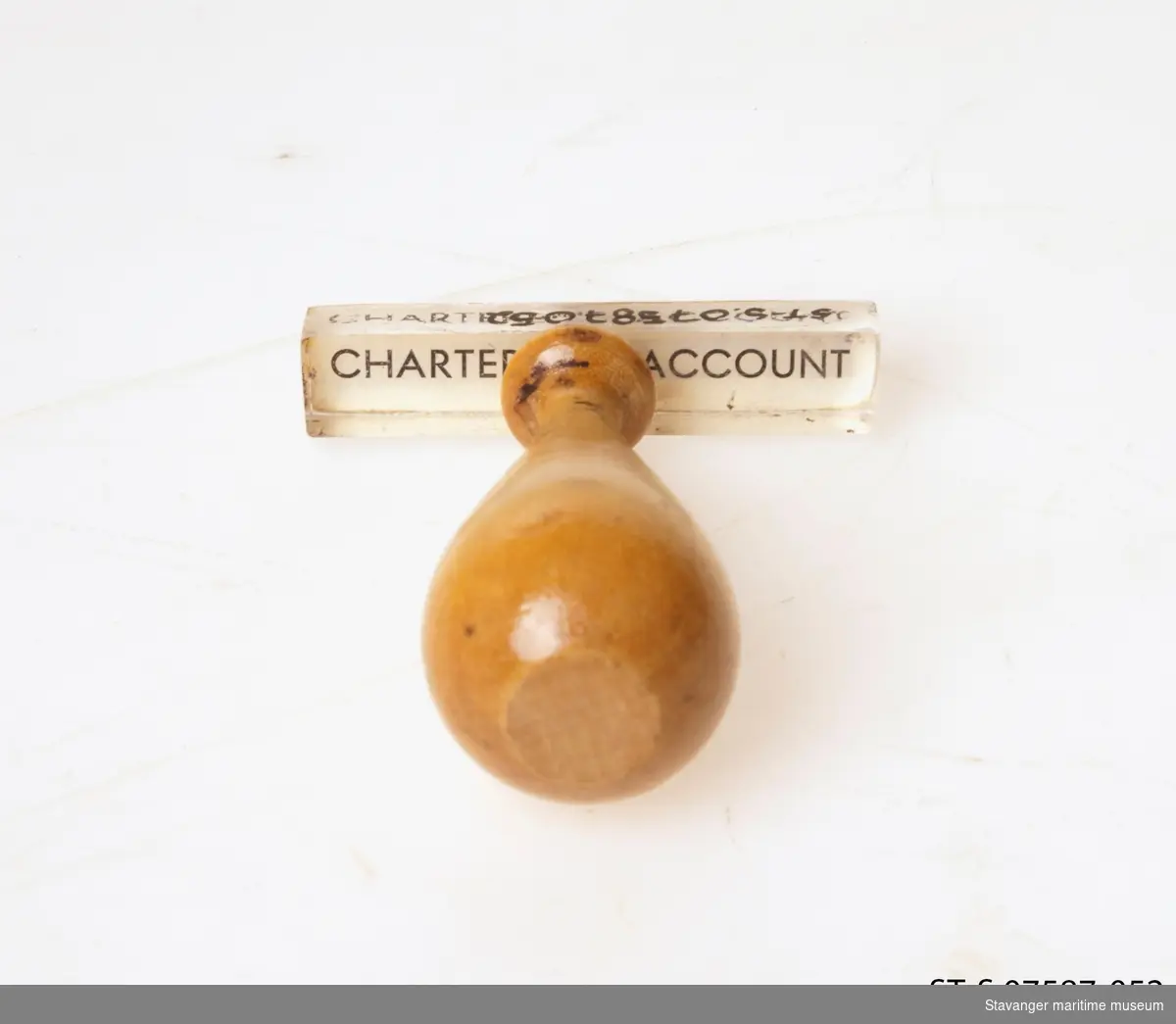 Stempel i tre og glass, hvor det står: Charterer's Account.