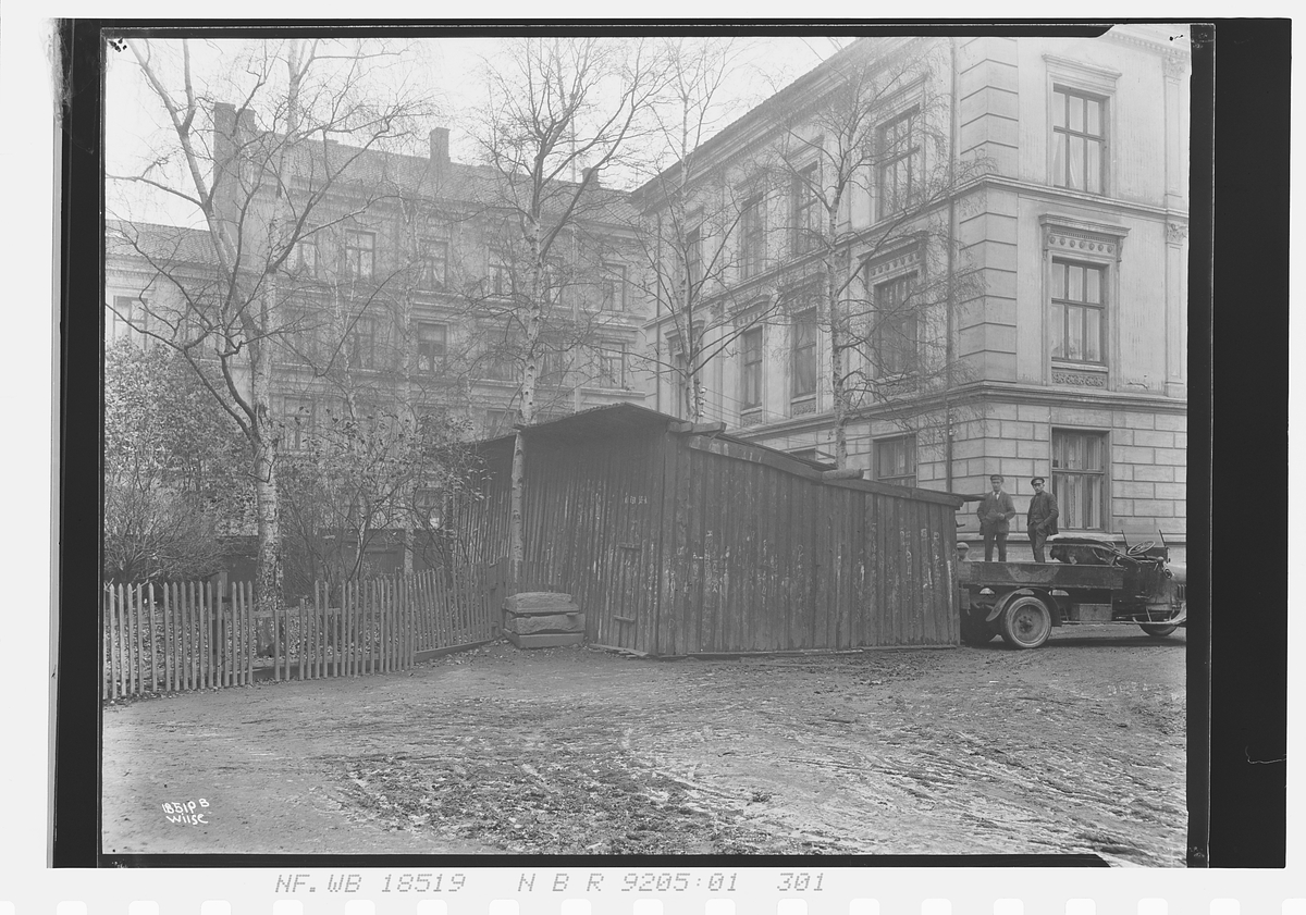 Lastebil står ved brenselsutsalg mellom to bygårder, Wergelandsveien. Fotografert 1924.