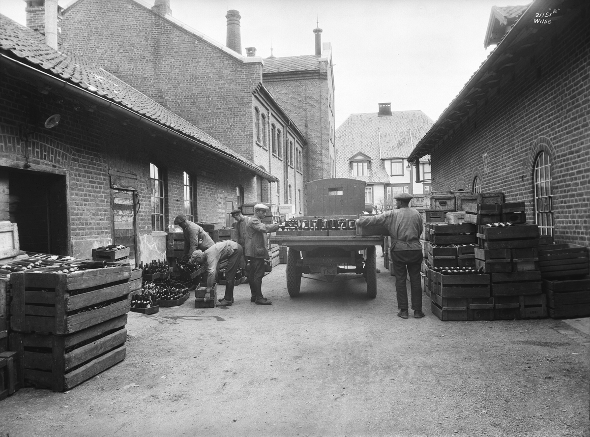 Byggeriarbeidere setter ølkasser på bil. Lillehammer Bryggeri. Fotografert 1927.