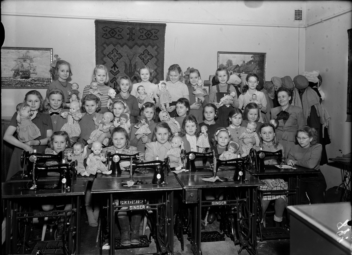 Barn med dockor vid Singer symaskiner, Uppsala 1950