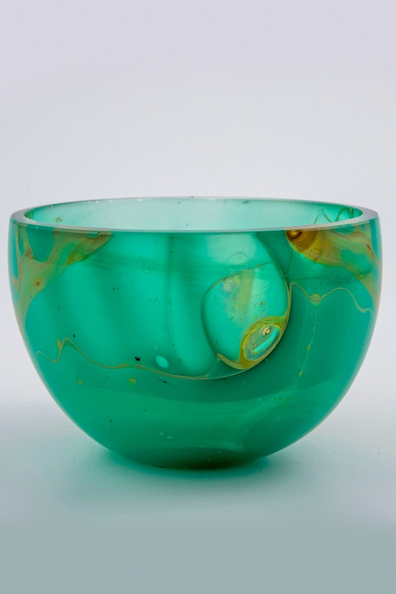Vase i flerfarget glass i underfangsteknikk. Korpus er utført i turkisfarget glass, dekorert med slyngende partier i brunt. Nedre del av vasen er tilnærmet opak, mens øvre del er halvgjennomskinnelig. På enkelte steder er det fargede sjiktet slipt vekk, slik at det oppstår små "punkter" med  klart glass.