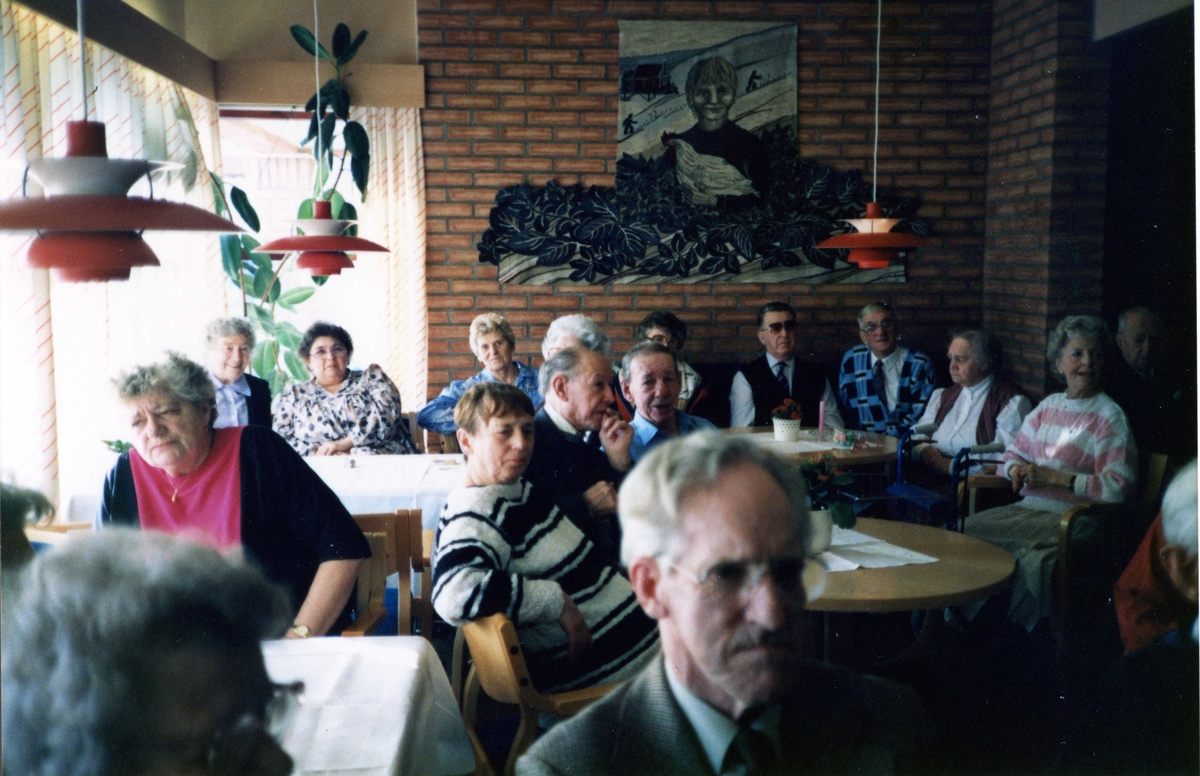 Flera personer är samlade på Brattåsgården, 1990-tal. Från vänster: Sonja Hagman (röd tröja), Inger Seger (blommig blus), Kajsa Parkström, Börje Parkström (mörka glasögon) och Arne Le Claire (grön tröja). Längst fram sitter Nils Dahl.