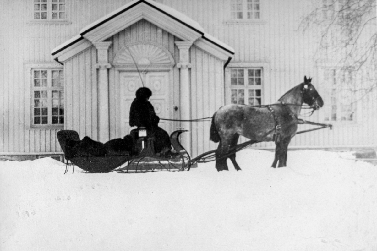 Olaf Berntsen 1883-1960, venter på "Sjølfolket" utenfor hovedbygningen på Staur gård i Stange. Heste og slede, hestekjøretøy.