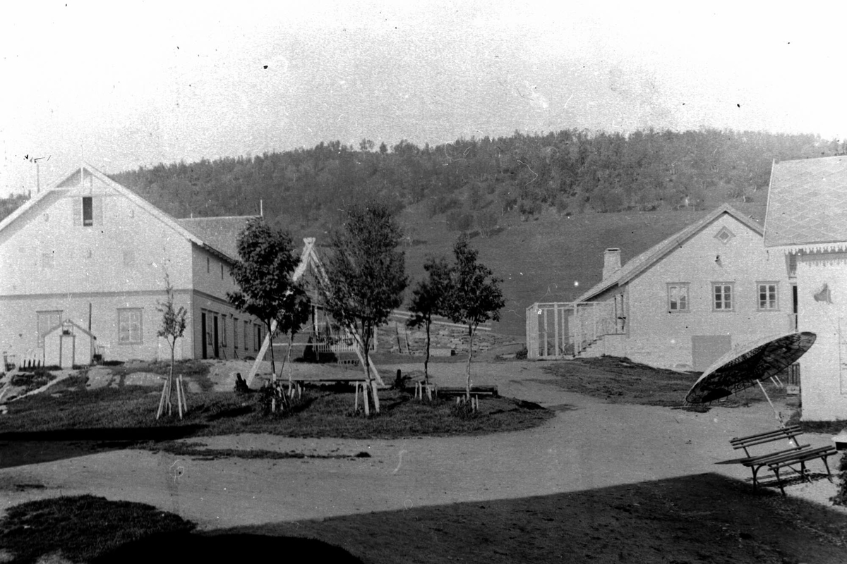 Gårdstun på Kaarbøgården med tre bygninger rundt.