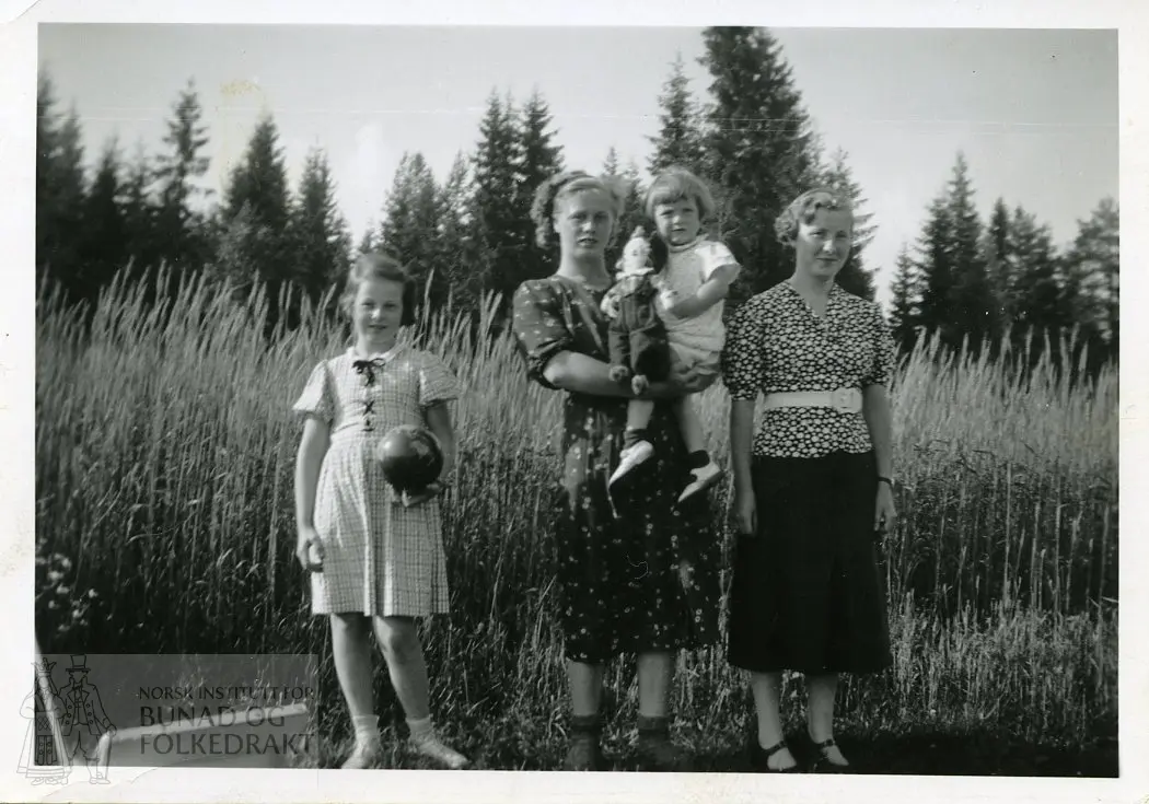 Kvinner og barn foran en kornåker