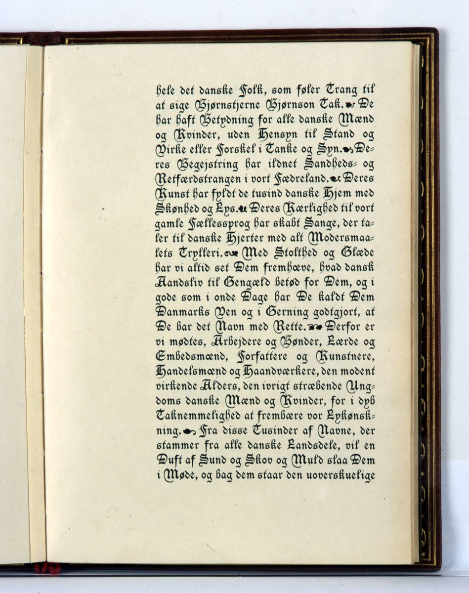 Adresse innbundet i brunt skinn med preget dekor i olivengrønt og rødt. Rød tvinnet snor i ryggen med dusker. På innsiden grønn silke med gullborder og broderte blomster.