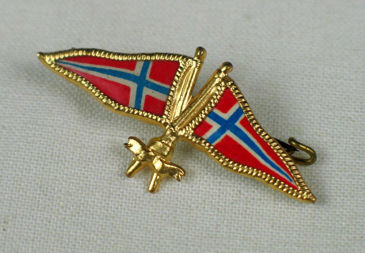 Nålen er gyllen og formet av to vimpler i norske farger.