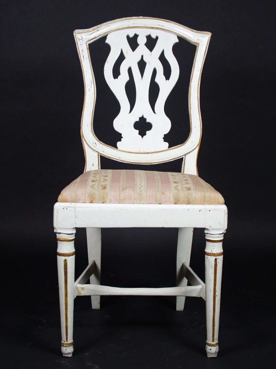 Stolen er i bjørk og gran, er hvitmalt med dekor i gull. Ryggbrettet er gjennombrutt og forbeina er runde, dreide og kannelerte. Stolen har løst sete som er stoppet med tekstiltrekk.