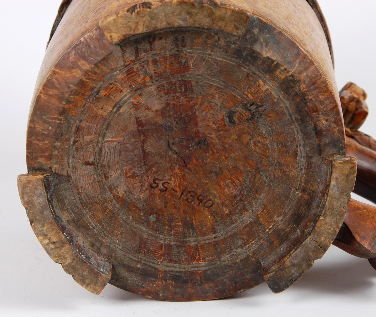 Kanne av dreid valbjørk. Lokk med akantusskurd. Løveformet lokkåpner. Hank med bladranke. Tre løveføtter.