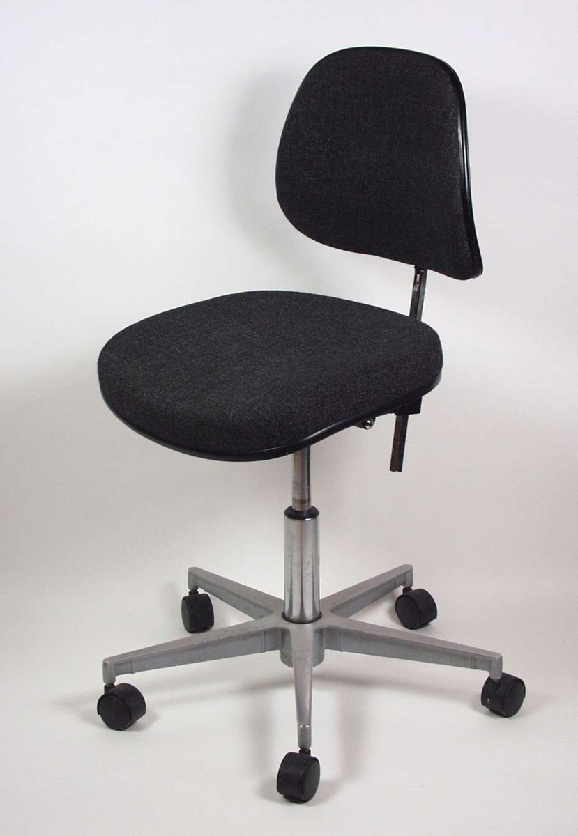 Kontorstol med rygg og sete trukket i svart stoff. Sølvlakkert metallunderstell med fem hjul. Justerbar rygg og sittehøyde.