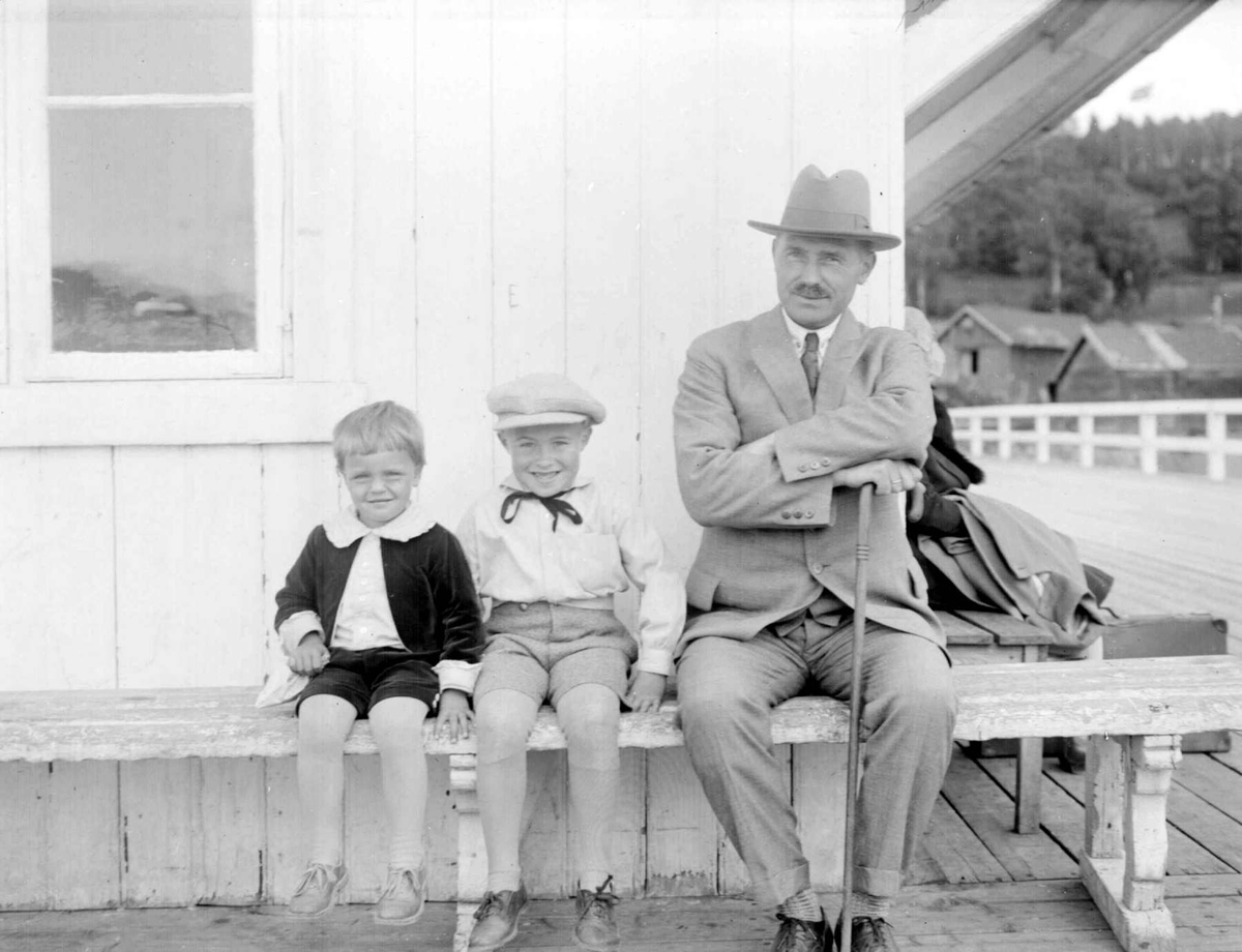 Eldre mann og to gutter på en benk på Bryggen. Odd Jens Bjerkli og Gunnar Berge. Lærer Bjerkli.