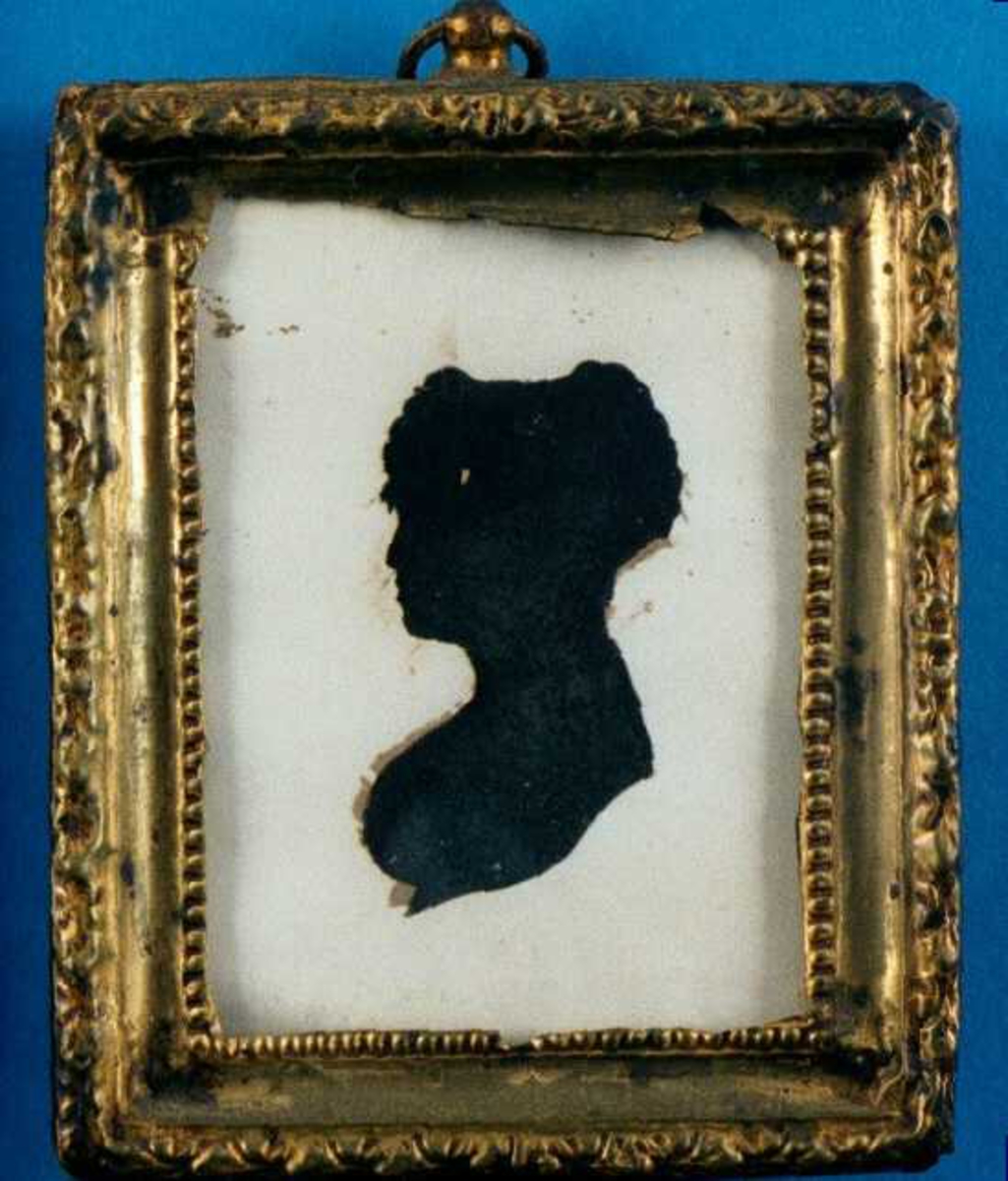Portrett av ung kvinne. Silhouett. Profil venstre, rund barm krøllet hår over pannen, stor flat chignon (flettet?), nedskåret bue over isse 