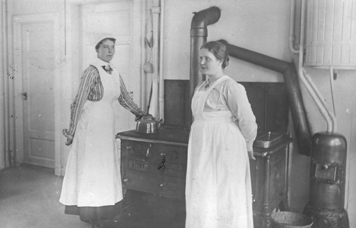 Follo tuberkulosehjem. To ansatte ved komfyren på kjøkkenet.