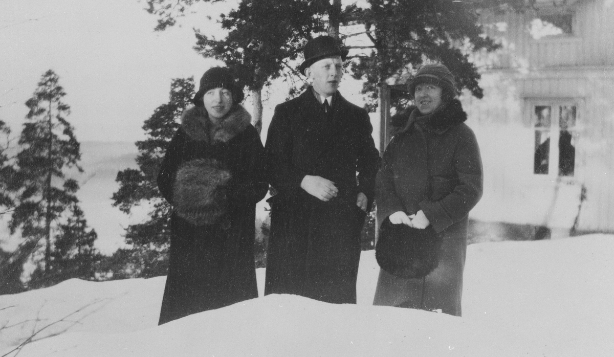 To søstre og en bror (Edith, Signe, Birger) vinterkledd utenfor huset.