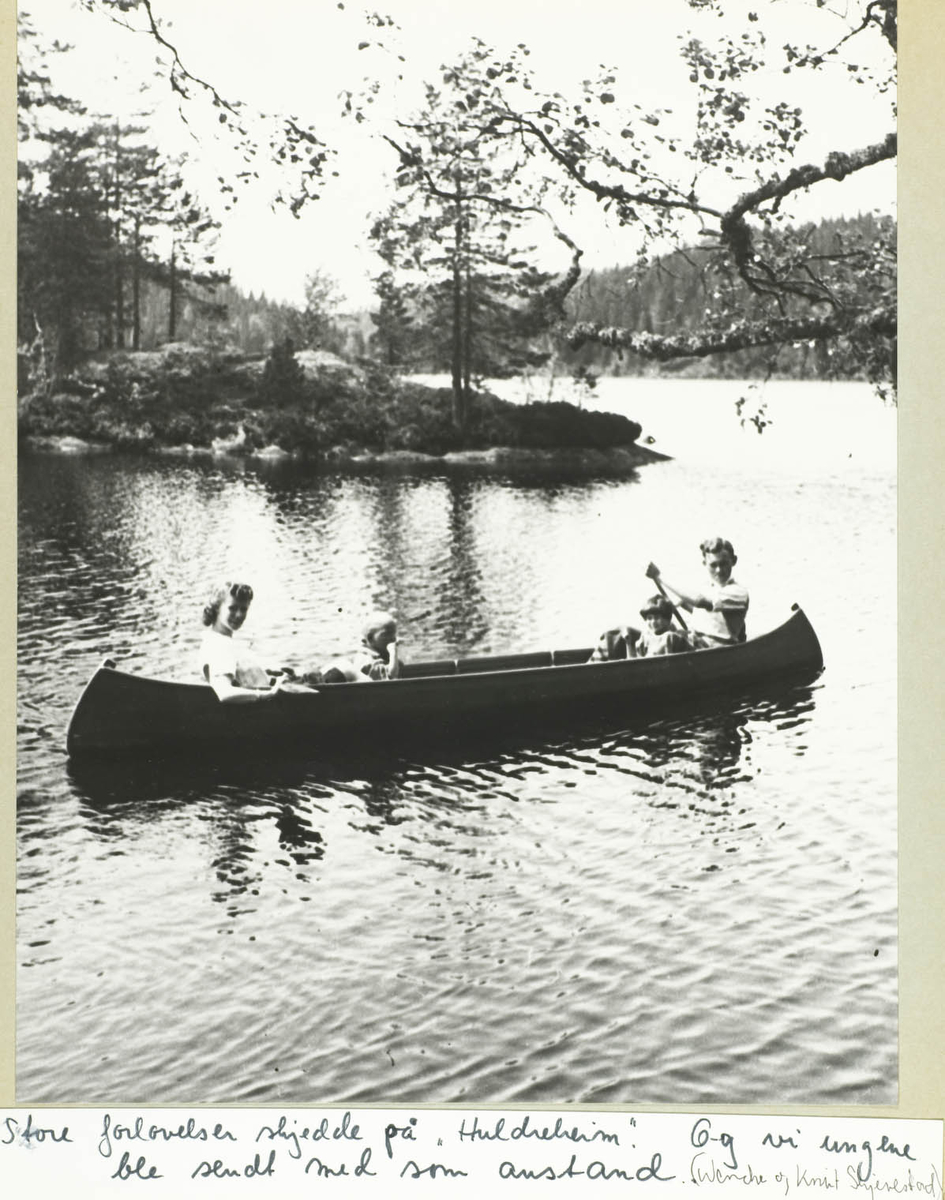 To barn og to voksne i kano på Ramstadsjøen