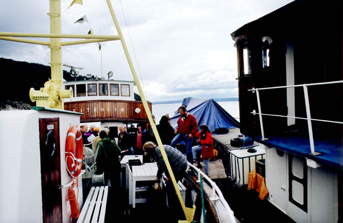 Oslofjorden. Båt/fiskeskøyte ligger ved kai: Eitrheim. Mennesker på vei til å gå om bord. 