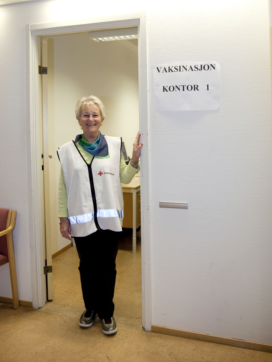 Svineinfluensa. Vaksinasjon mot svineinfluensa på Skedsmo Rådhus den 20.11.09. Vaksinasjonsområde. En frivillig fra Røde Kors hilser velkommen inn til en av vaksinasjonskontorene.