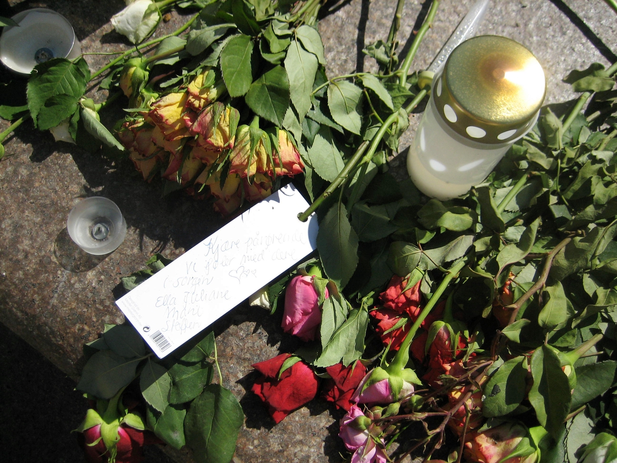 Minner etter terrorhandlingen den 22. juli 2011. Blomster, kort og lykter på fontene på Lillestrøm torg.