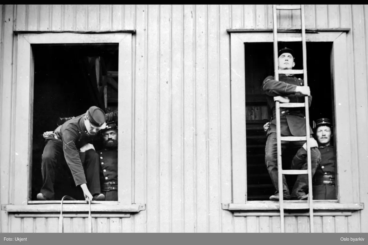 Brannmenn som øver - klatring ut av vinduer
