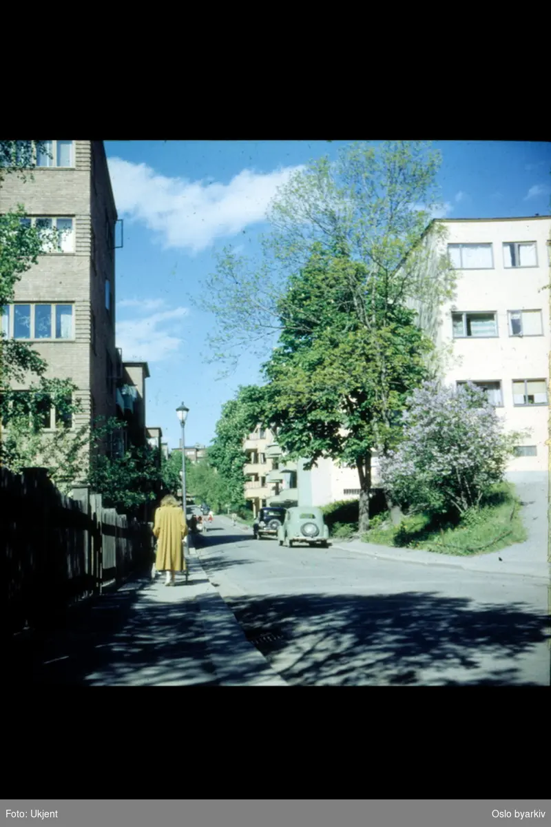 Fearnleys gate, sommerdag, kvinne med gul kåpe som triller vogn