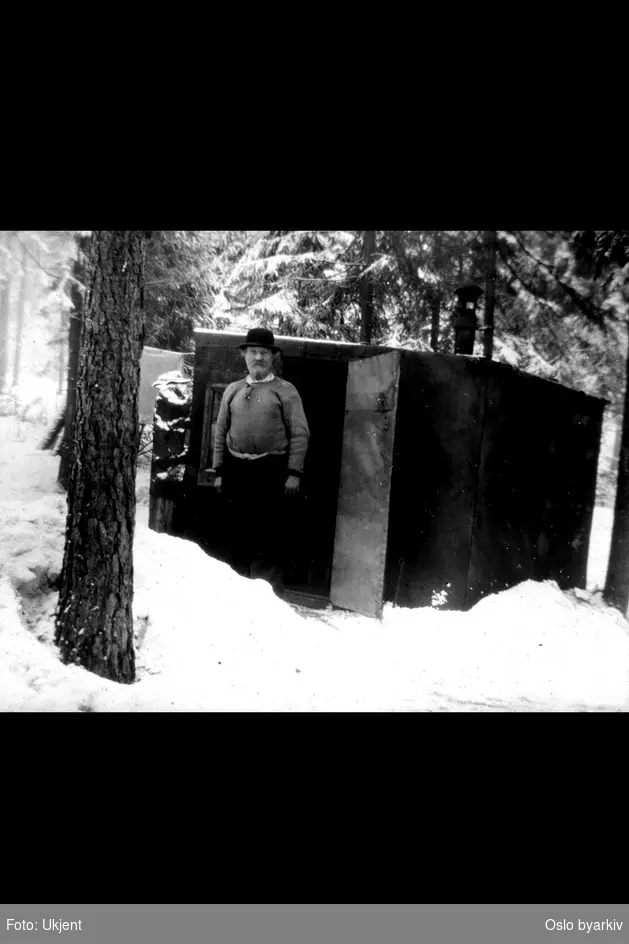 Provisorisk hytte i Abildsøskogen, mann med hatt foran døra