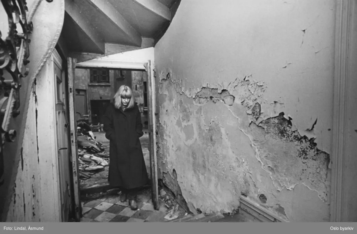 Kvinne i døråpningen mot en forslummet bakgård. Fotografiet er fra prosjektet og boka ''Oslo-bilder. En fotografisk dokumentasjon av bo og leveforhold i 1981 - 82''. Kontakt Samfoto ved ev. bestilling av kopier.