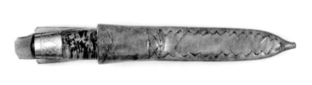 Tollekniv med slire, der knivbladet er smidd ved Brusletto-fabrikken på Geilo, mens skaftet og slirta er lagd av Henrik [Heikki] Leikåsen (1899-1991) fra Grue Finnskog, som begynte å lage kniver i 1930-åra. Kniven er 21,8 centimeter lang, målt fra bladspissen til og med knappen i den bakre enden av skaftet. Bladet utgjør drøyt 9,7 centimeter av lengdemålet. Dette er et midtmål, for holken i den fremre skaftenden har en avrundet front. Største bredde er 2,2 centimeter, et stykke framfor midten av bladet. Den bakre delen av bladryggen er rettlinjet, men drøyt 4 centimeter i den fremre enden hary en konkavt buet nedslipning mot bladspissen. Produsenten har stemplet den venstre sida av knivbladet «BRUSLETTO GEILO MADE IN NORWAY». Skaftet er lagd av flammet bjørkeved. Det er i underkant av 11,0 centimeter langt, inkludert nysølvholkene i endene. Treet er insatt med lys gulbrun beis som framhever vedstrukturen og overstrøket med klarlakk. Endeholkene har graverte mønstere. I den bakre enden av skaftet, er enden av «tangen» - jernteinen, som i forlengelsen av knivbladet er tappet gjennom den sentrale delen av skaftet - forankret i ei 1,0 centimeter høy messinghylse, en såkalt «knapp».

Slira er sydd av om lag 2,7 millimeter tjukt lysebrunt lær. Den er 16,9 centimeter lang. Dette lengdemålet innbefatter ikke opphenget. Slira er 3,4 centimeter bred ved munningen. Den er rett og symmetrisk om midtaksen i lengderetningen. Den øvre delen av slira, som skulle omslutte den fremre delen av knivskaftet er «rundoval». Den nedre delen av slira, som skulle skjerme knivbladet, er mer «flattrykt». Sliresommen er plassert på den sida som skulle vende inn mot kroppen når knivstellet hang i bukselinninga. Forsida av slira er dekorert med siksaklinjer. Lærets ytterflater er overstrøket med klarlakk. På baksida av sliremunningen er det påsydd to lærstropper. Den fremsta av dem er den lengste. Den har et avlangt hull som skulle tres over knappen i skaftets bakende, for å forhindre at kniven uforvarende falt ut av slira. Den bakre har et knapphull, til bruk når knivstellet skulle bæres på et klesplagg. En lærlapp på innsida av sliremunningens bakside skulle enten kompensere for at denne sliredelen var litt for romslig i forhold til tjukkelsen på knivskaftet, eventuelt for å beskytte den blanklakkerte overflata på skaftet for ripeskader fra opphengssømmen.