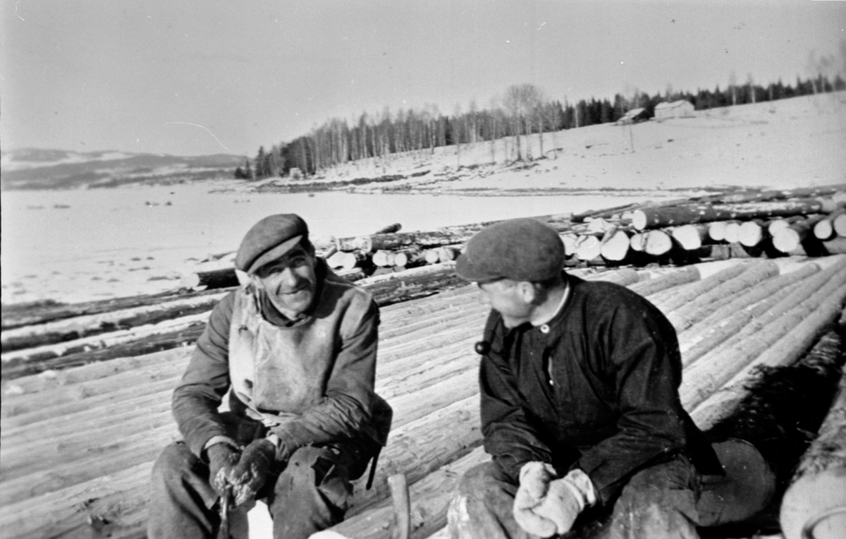 Merking av tømmer på stranda nedenfor Dompidal gård, Gaupen, Ringsaker. Anders Voldsengen og Kolbjørn Dårstad med pipe.