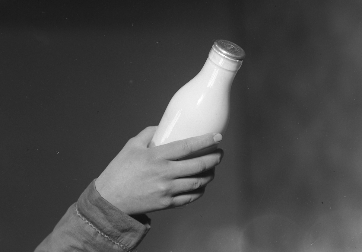 Melkeflaske påsatt flaskekapsler med spesialtang - Bergs Maskin