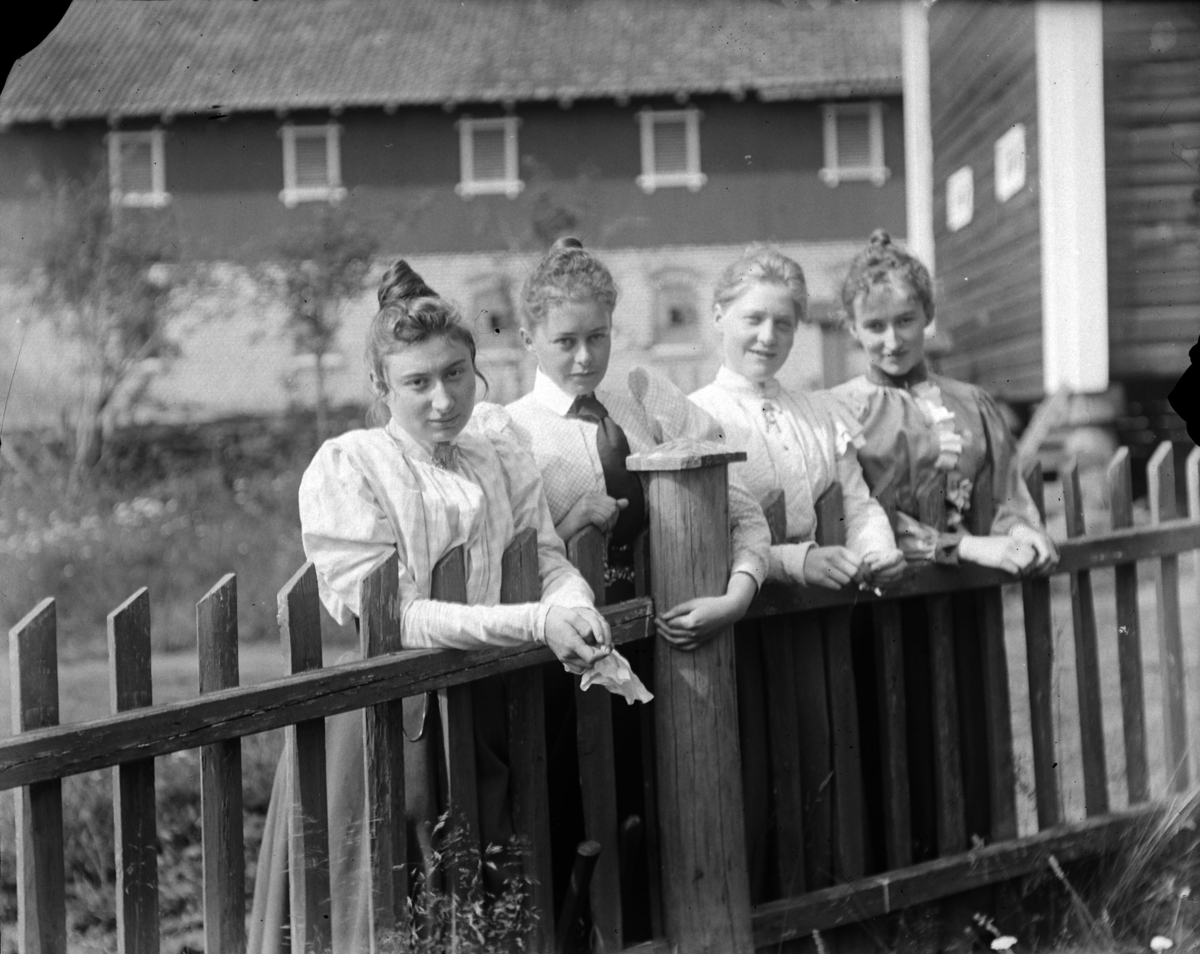 Fire kvinner ved et stakittgjerde. Sofie Pihl (f Mellbye) nummerr to fra venstre. På Grefsheim, Nes, Hedmark.
