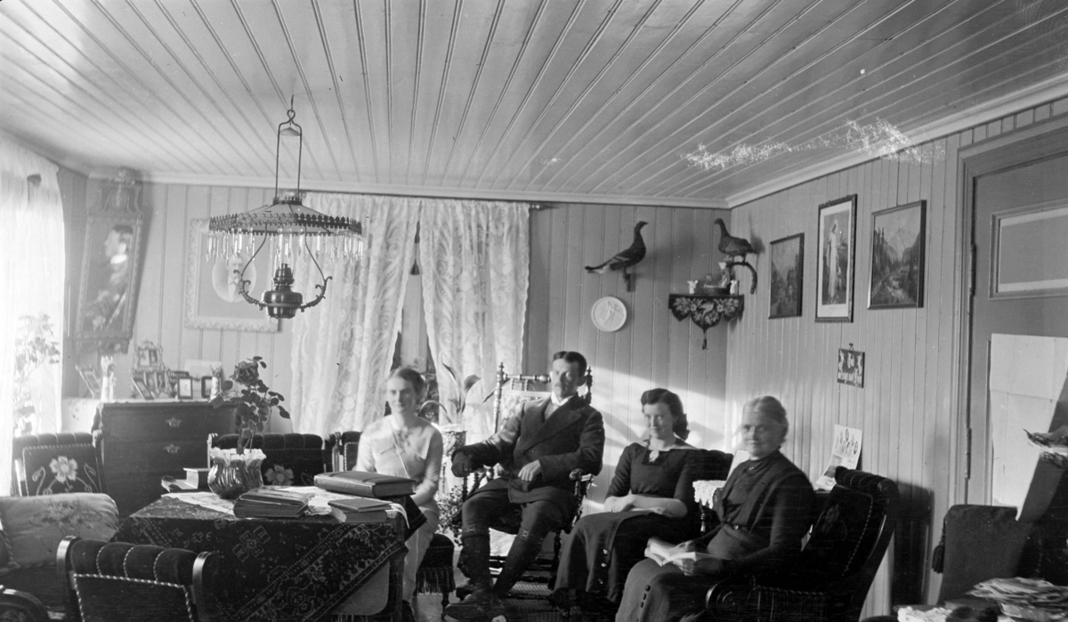 Interiør: stue, lampe, møbler på Kise østre, Nes, Hedmark. Fra venstre er Else f.1891 , ?, Margit (1895-1973), Tina Skredshoel (1857-1939).