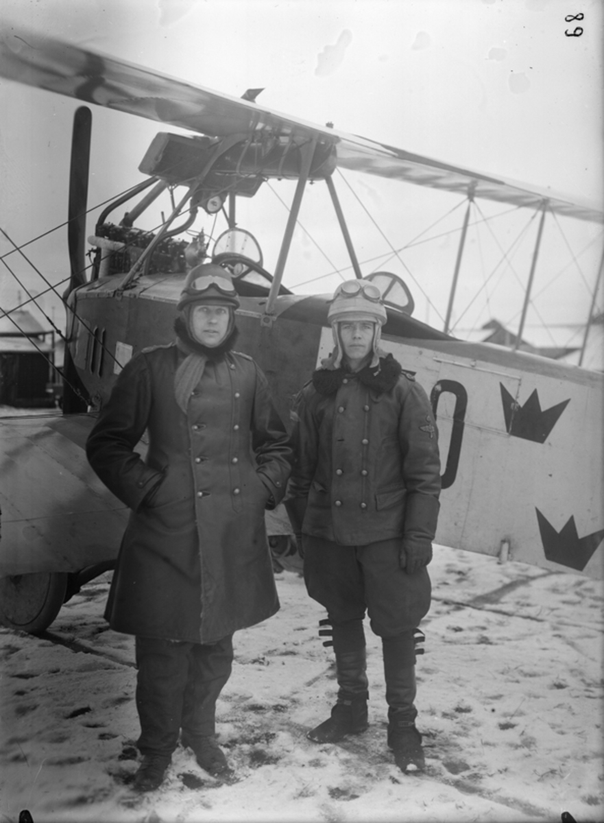Två män ståendes framför flygplan Albatros, vintertid.