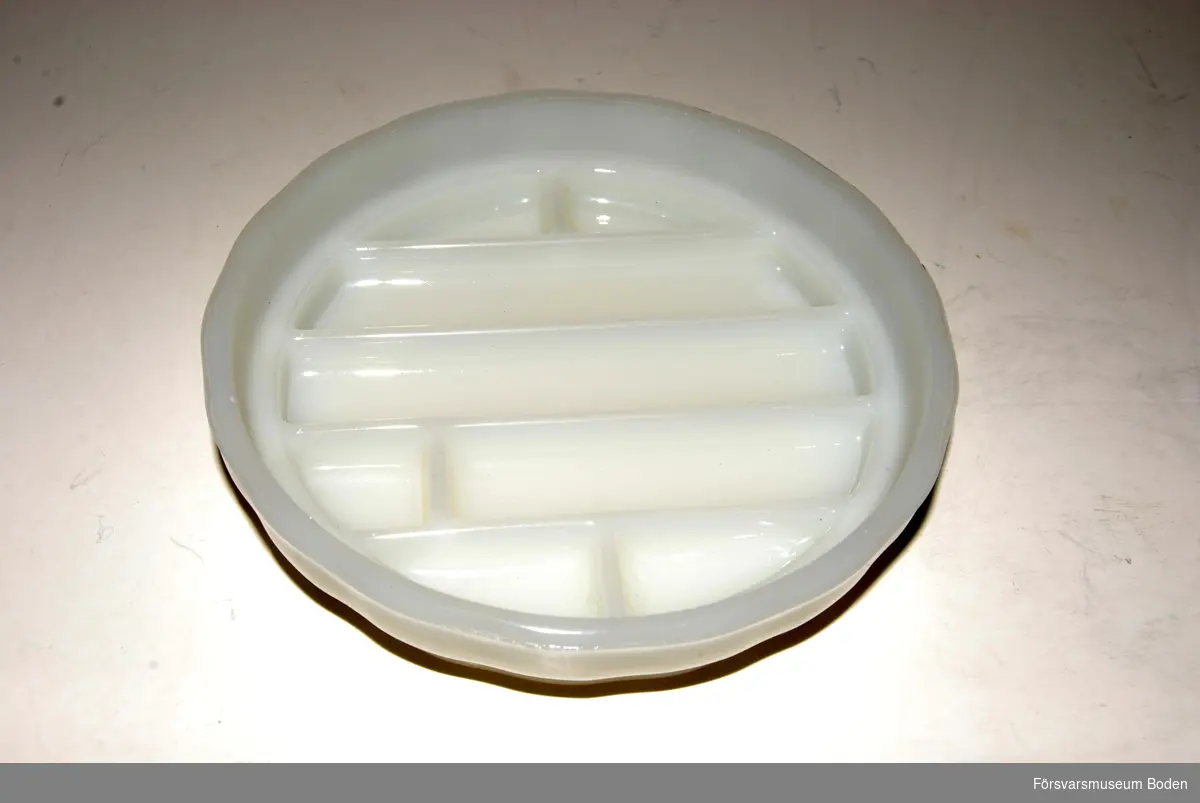 Skål av opalglas med lock. Indelad i fack och avsedd för förvaring och desinfektion av tandläkarinstrument. Tillverkad av Alfred Becht, Offenburg, Tyskland.