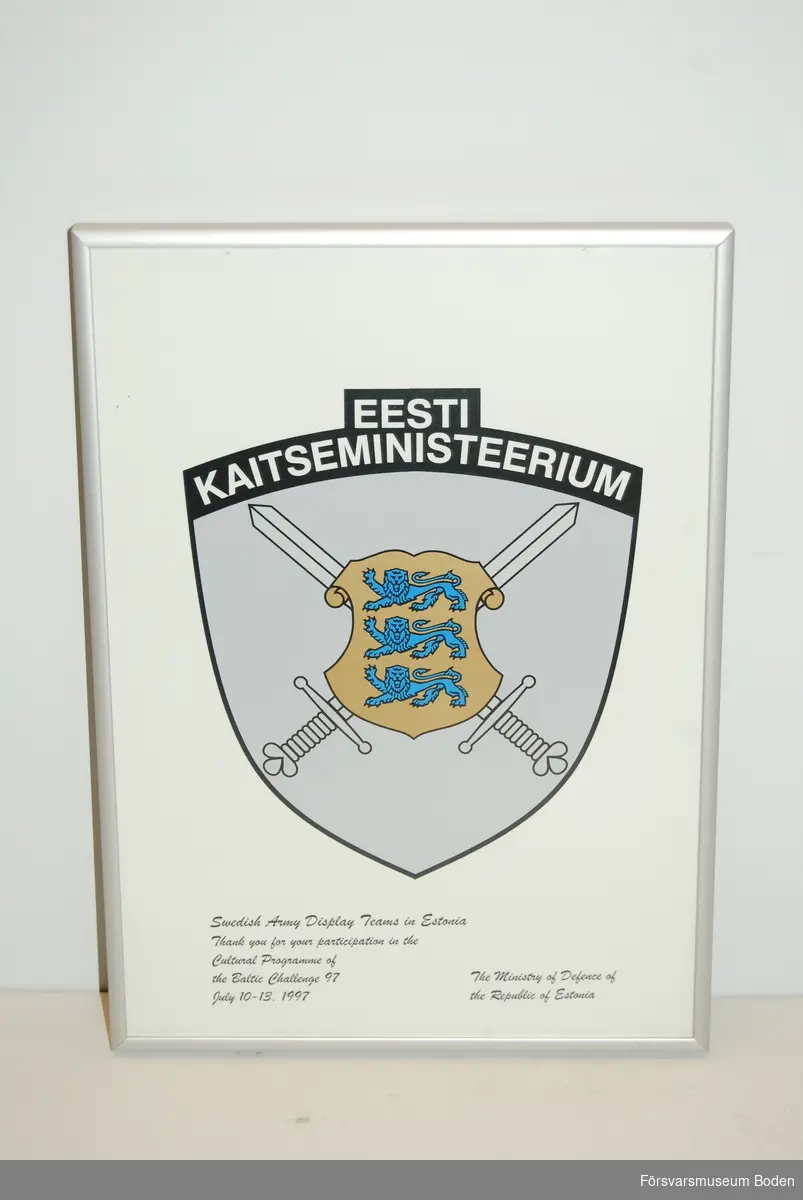 Gåva till Arméns musikkår Norrland, men enligt texten på tavlan dedicerad till "Swedish Army Display Teams". Ramens yttermått 21 x 28,5 cm. Ingen märkning på baksidan.