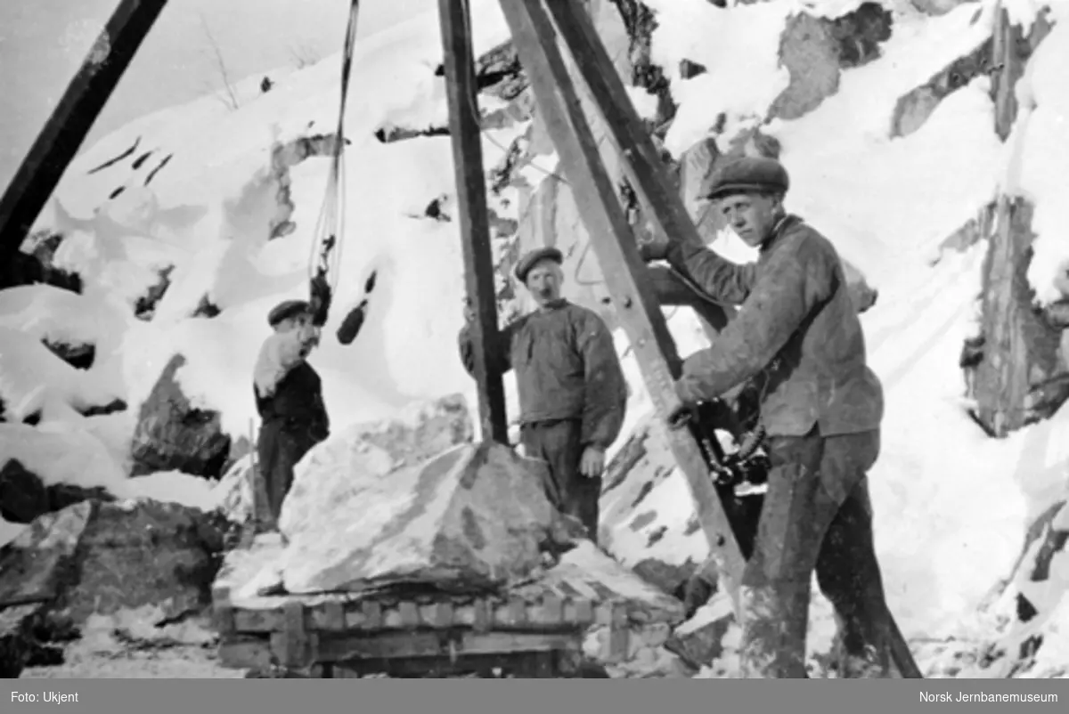 Tre mann i arbeid med en stubbebryter ved Berghammeren, pæl 2238, fra sør