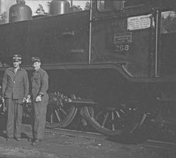 Lokomotivfører og fyrbøter foran damplokomotiv type 20b nr. 