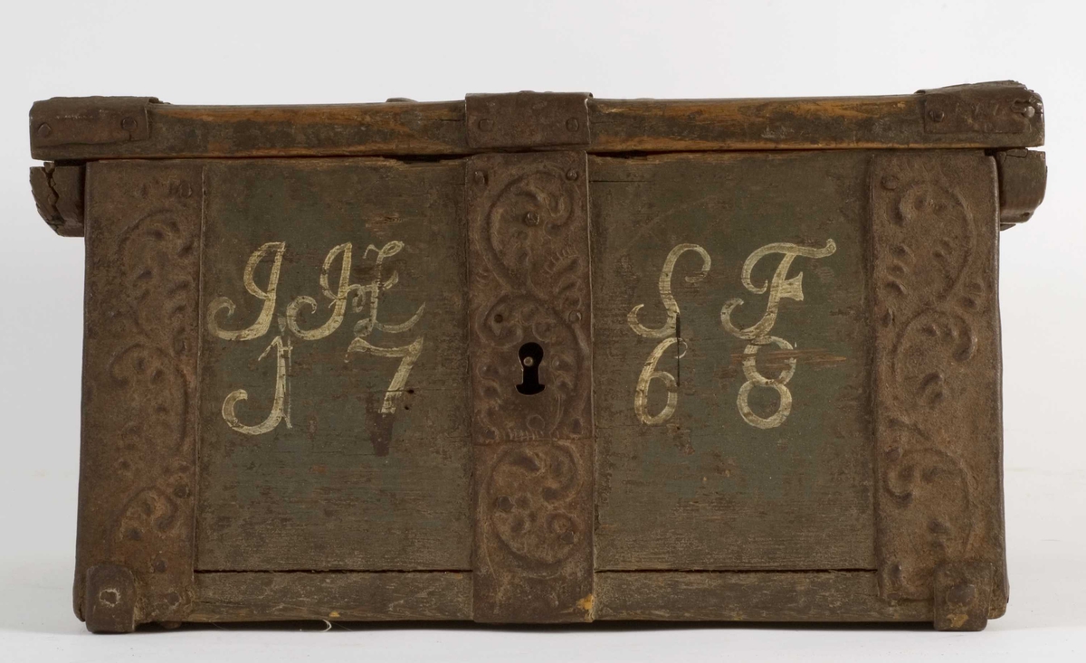 Ferdaskrin i tre med brede jernbeslag i dreven dekor.