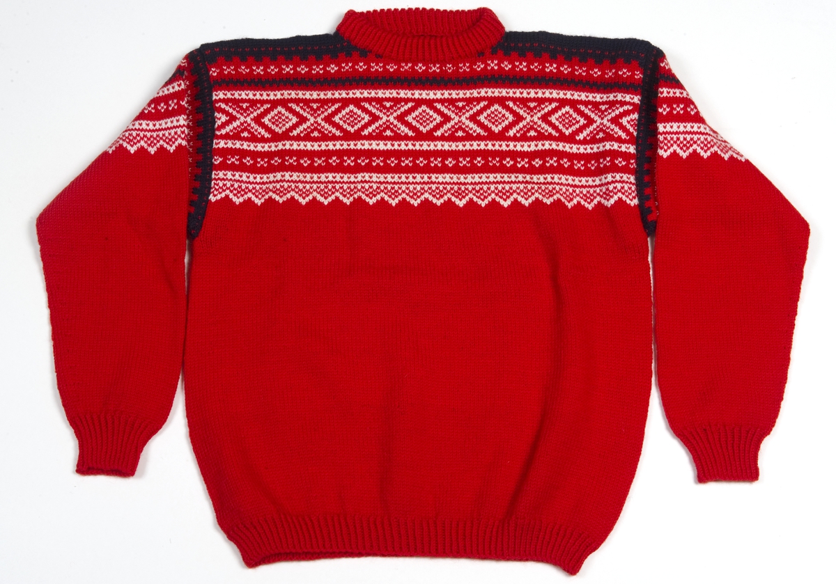 Rød strikket genser med mønster i hvit og svart.