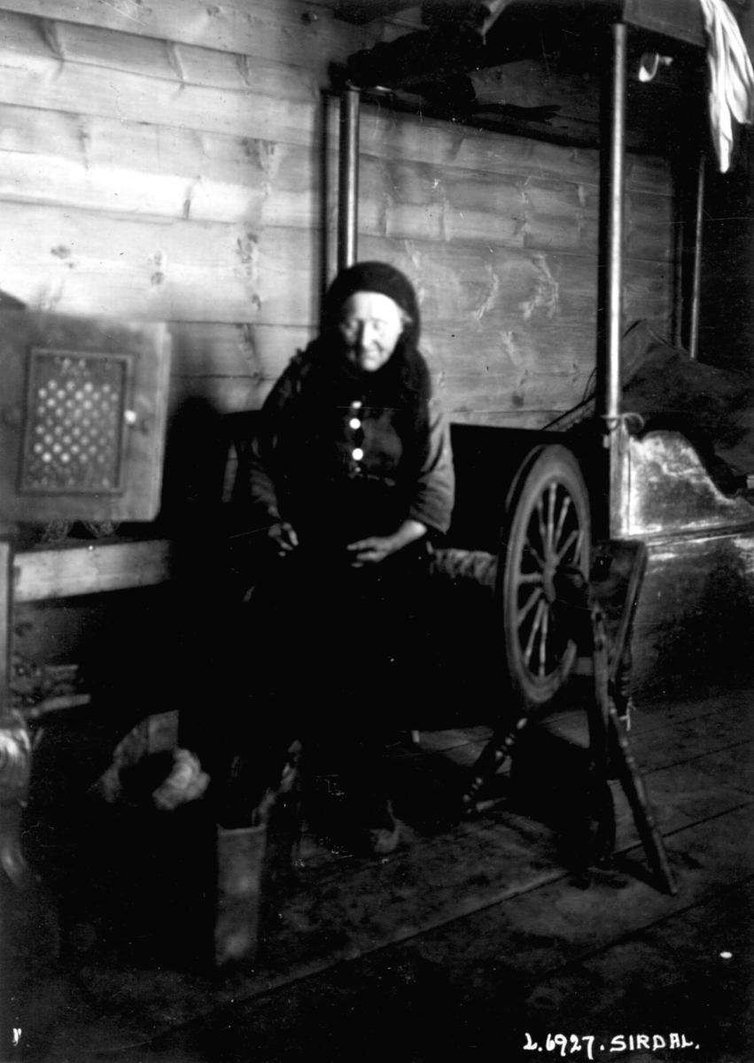 Spinning av "lampegarn" til skiladder. Karen Tonetta Olsdatter Skreå (1860-1943) spinner på rokk. Fra gnr. 17 Skreå, bnr. 4, "Kvæven", Sirdal, Vest-Agder. Rokken hun spinner lampegarn på, kalles en lamperokk.