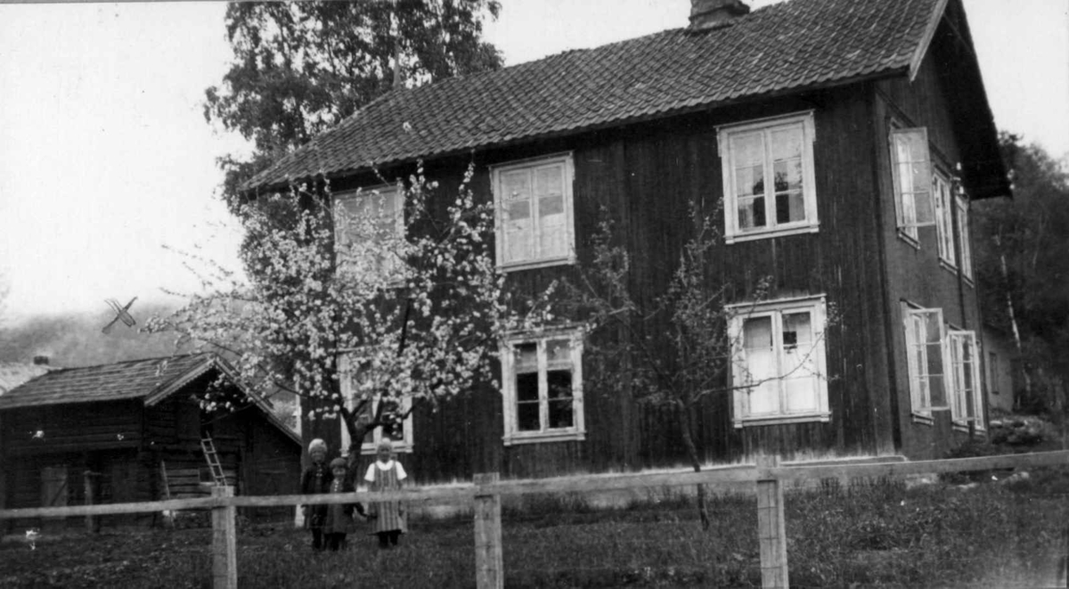 Gården Folkestad i Folkestadbyen, Fyresdal, Telemark. Barn i hagen foran vånigshus og stall til venstre.