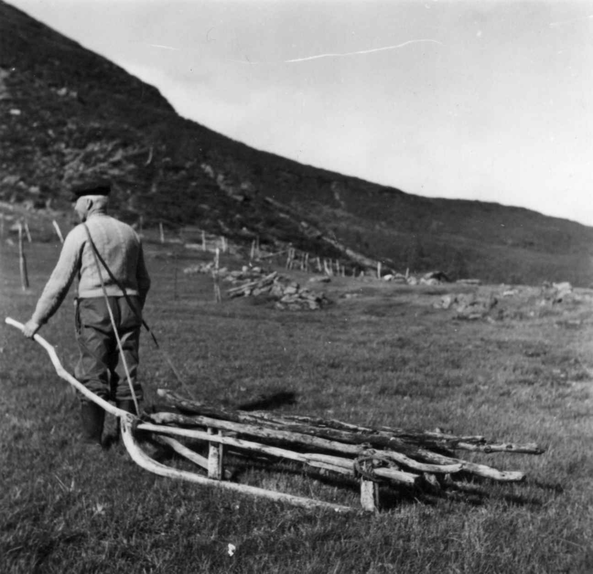 Mann med ved- og høykjelke med trekkstang og styrestang. Stordalen 1955.