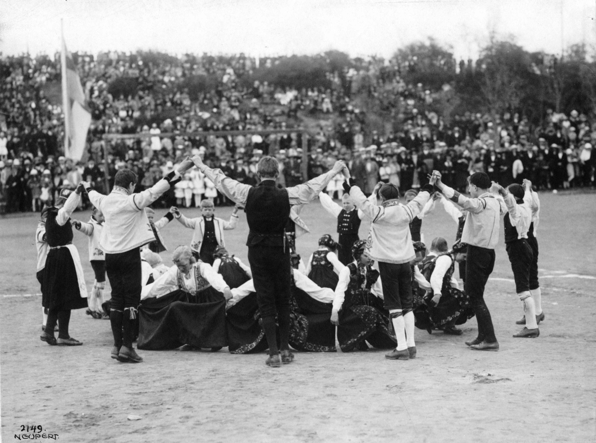 Folkedans. Oppvising på vårfest på Hovedøya, Oslo 1924. Barn og voksne. Publikum i bakgrunnen.