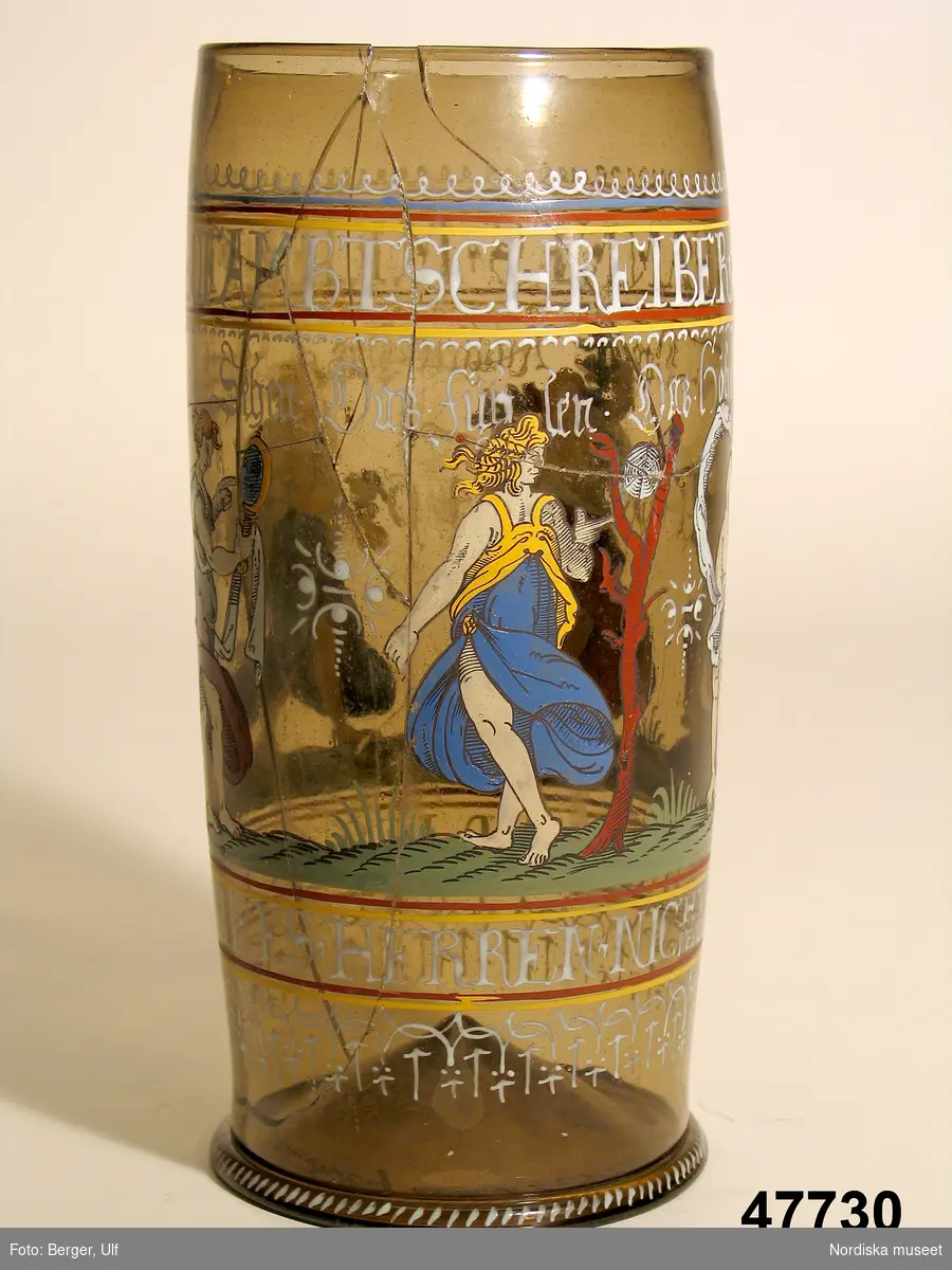 Montertext i Dukade bord:	
Ölglas, så kallat "Humpen", med emaljmålad dekor, daterat 1646. Tillverkat i Sydtyskland.  