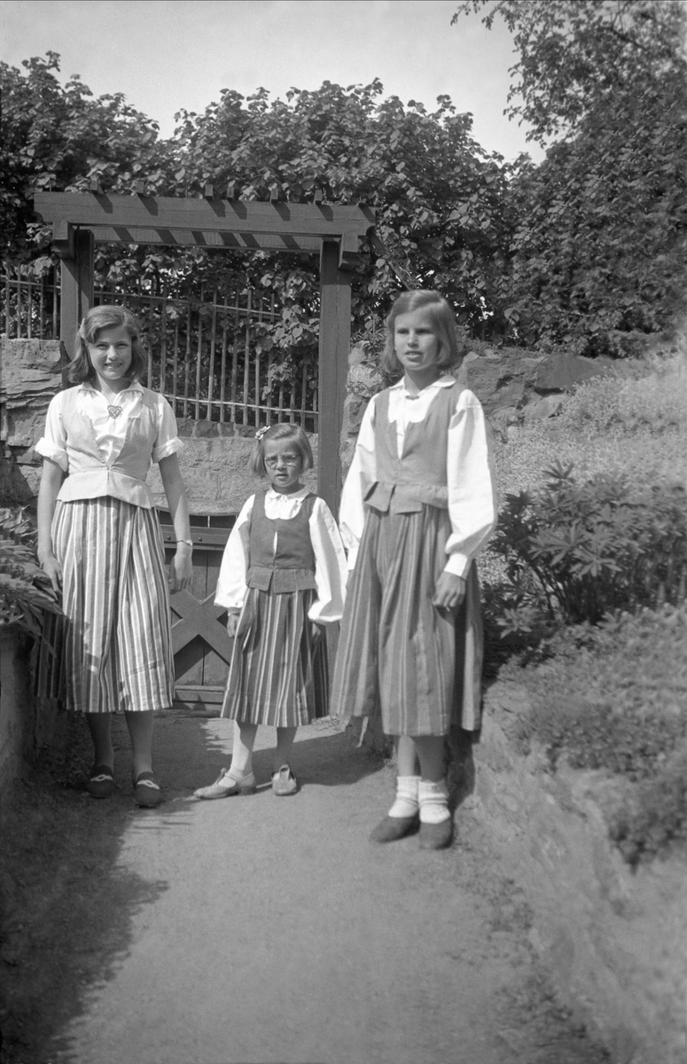 Søstrene Arentz i hjemmesydde festdrakte ri hagen på Bygdøy 1943. Fra venstre Siri, Kari og Guri.