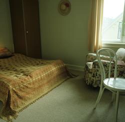 Seng med sengeteppe, stol og skap i herskapshus, Frogner. Il