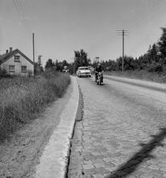 Langs Riksvei 1 kjører en motorsyklist foran en bil og et hu