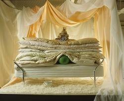 Samling av dyner med edderdunsdyne og grågåsdyne på toppen. 